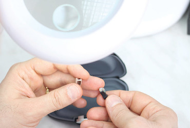 An audiologist repairs hearing aids