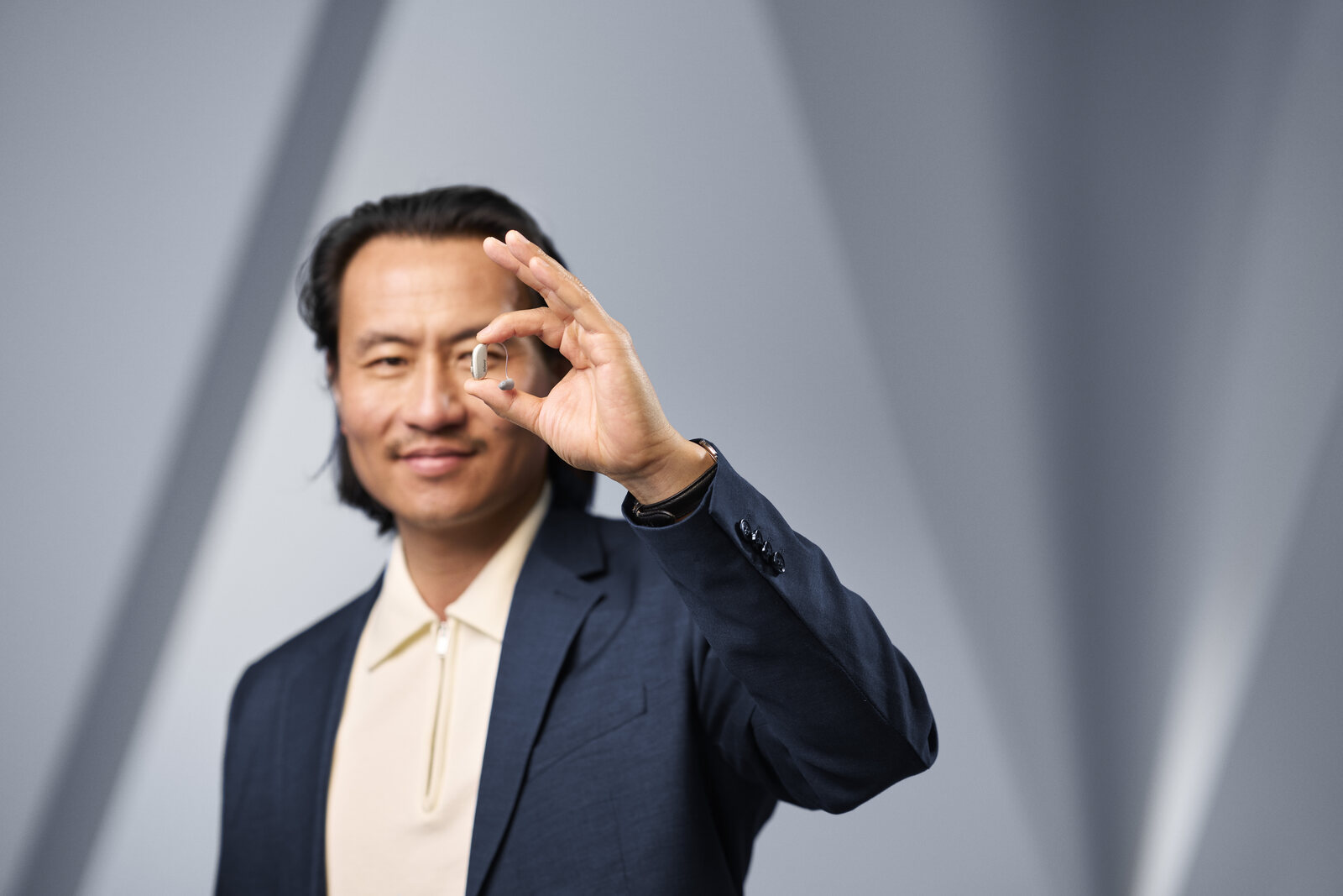 A man holding a ReSound Sensia hearing aid